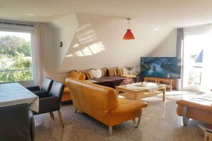A modern living room with a sofa, coffee table, and television. - Holiday apartment with 2 bedrooms (Koserow)