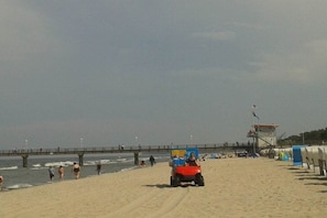 A beach with a lifeguard tower, a pier, and a signboard. - Holiday apartment with 2 bedrooms (Zinnowitz)