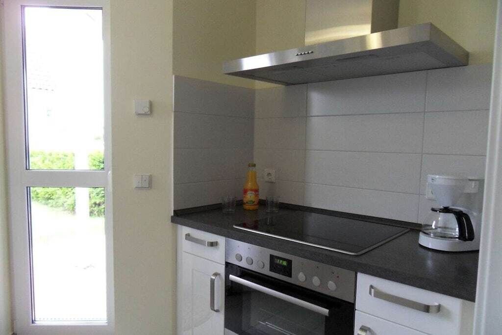 A kitchen with a stove, oven, and a coffee maker.