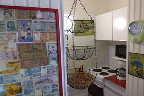 Une cuisine avec des paniers suspendus, un poêle et un mur orné de billets de banque.