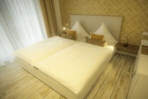 A hotel room with a large bed, two bedside tables, and a headboard with a quilted pattern.