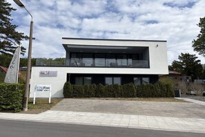 A modern two-story building with a flat roof, large windows, and a balcony. - Villa in Sellin with swimming pool (Sellin)