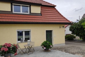 A two-story house with a red-tiled roof, a small balcony, and a front door. - Holiday home Anna in Hirschau (Hirschau)