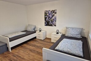 A bedroom with two single beds, a nightstand, a dresser, and a wall-mounted picture. - Holiday home Anna in Hirschau (Hirschau)