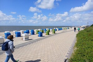 A paved walkway with seating areas and a view of the sea. - Holiday apartment with 2 bedrooms (Wyk auf Föhr)