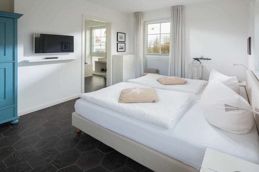 Une chambre d’hôtel avec un lit, un téléviseur fixé au mur et une vue sur l’extérieur.