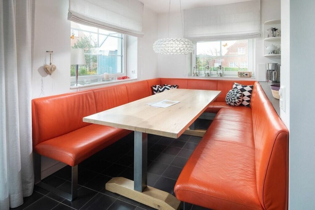 Une cuisine moderne avec une table en bois et des sièges en cuir orange.