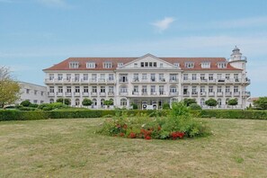 A large, multi-story building with a symmetrical facade, multiple windows, and a central entrance. - Holiday apartment Haus am Park 322251 (Kühlungsborn)