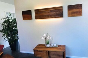 A room with a wooden console table, a potted plant, and three wooden wall art pieces. - Holiday home with 3 bedrooms (Karlshagen)