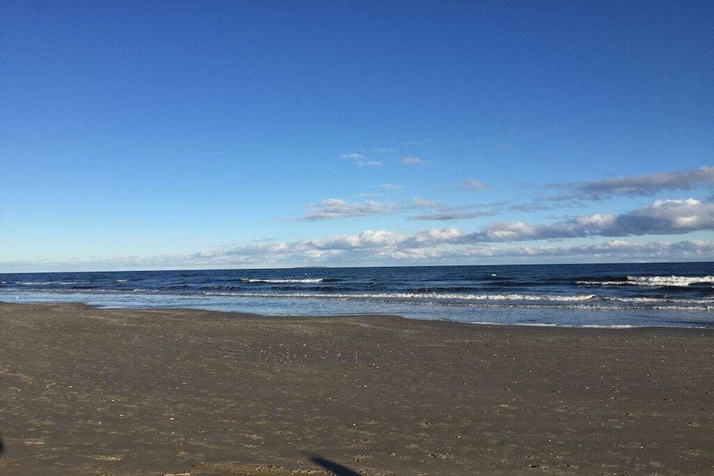 Ein Strand mit blauem Himmel und Meereswellen.