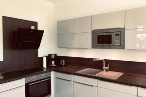 A modern kitchen with a built-in microwave, a coffee maker, and a sink. - Holiday home with 3 bedrooms (Karlshagen)