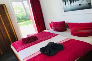 Een hotelkamer met een bed, een raam en een deur.