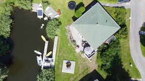An aerial view of a property with a dock, boats, a swimming pool, and a large building with a green roof. - Friesche Zusje Holiday Home with Terrace, Garden, Jetty & Wi-Fi in Makkum (Makkum)