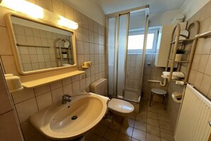 Een badkamer met een wastafel, toilet en douche.