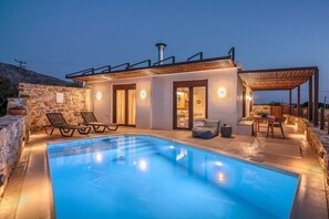 A modern villa with a swimming pool, stone walls, and a covered outdoor seating area. - Sia Elafonisi Pool House (Chrysoskalitissa, Kreta)