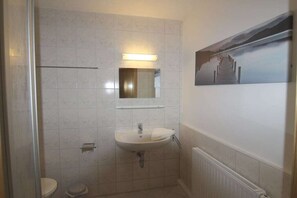 A bathroom with a toilet, sink, and a mirror. - Holiday apartment with 2 bedrooms (Crinitzberg)