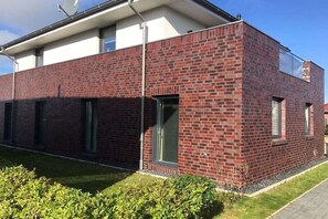 Ein modernes Gebäude mit Ziegelaußenwand, großen Fenstern und einem Flachdach.