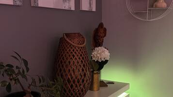 A modern interior with a white console table, a potted plant, a decorative vase, and wall art.