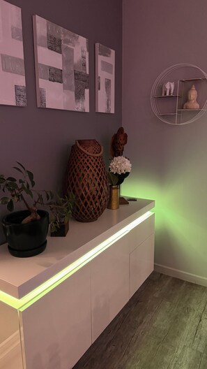 A modern interior with a white console table, a potted plant, a decorative vase, and wall art. - Villa with a private spa and hammam between Honfleur and Deauville (Villerville)