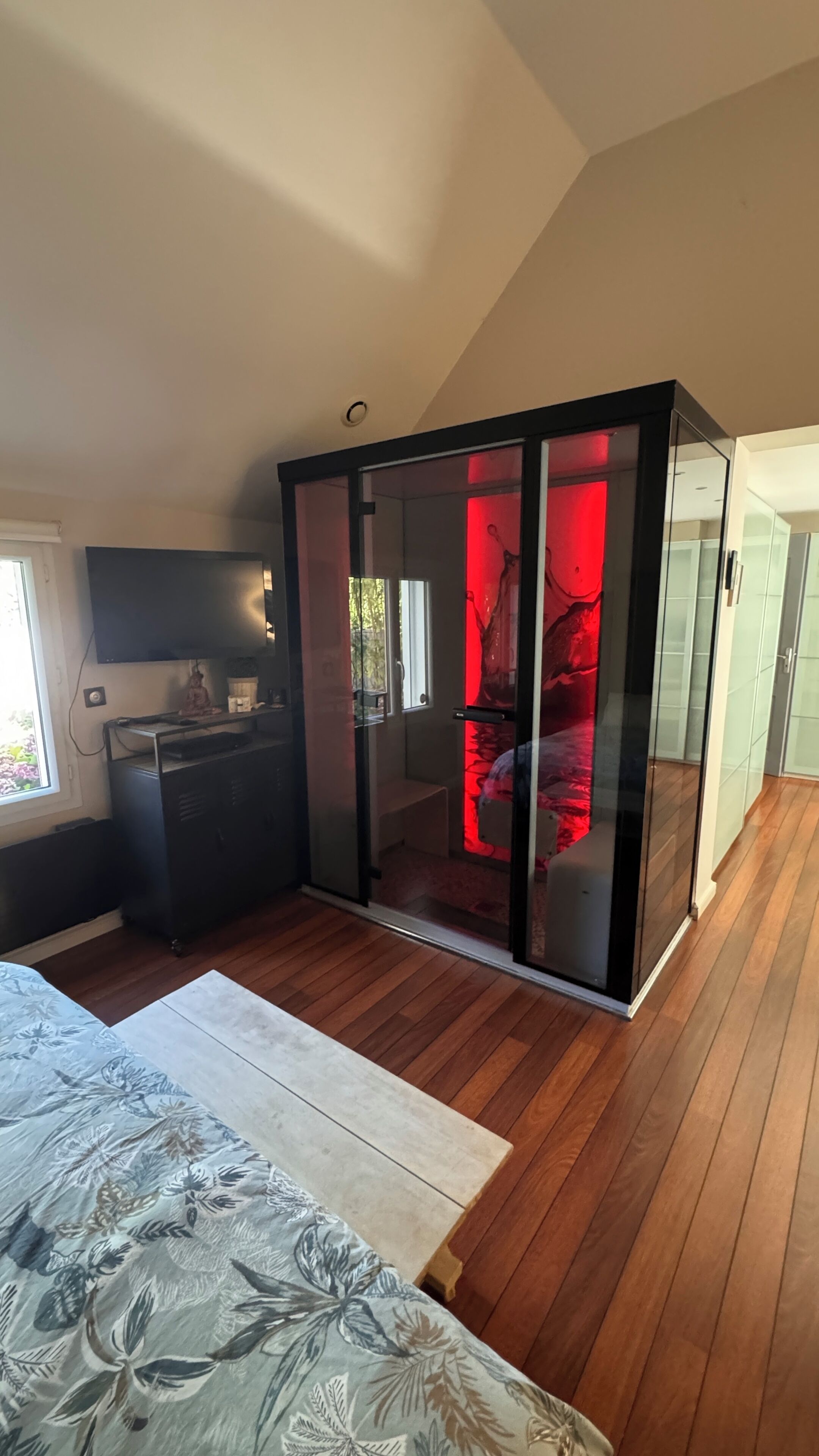 A modern bedroom with a bed, a desk, and a wardrobe.