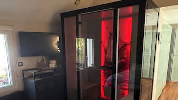 A modern bedroom with a bed, a desk, and a wardrobe.