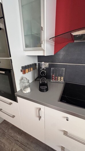 A kitchen with a coffee machine, spice rack, and a glass jar. - Villa with a private spa and hammam between Honfleur and Deauville (Villerville)