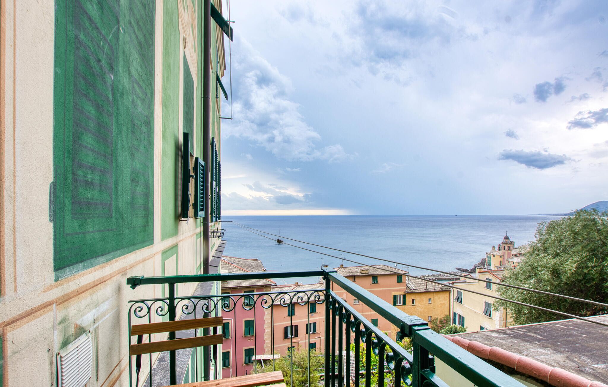 A balcony with a view of the sea and buildings.
