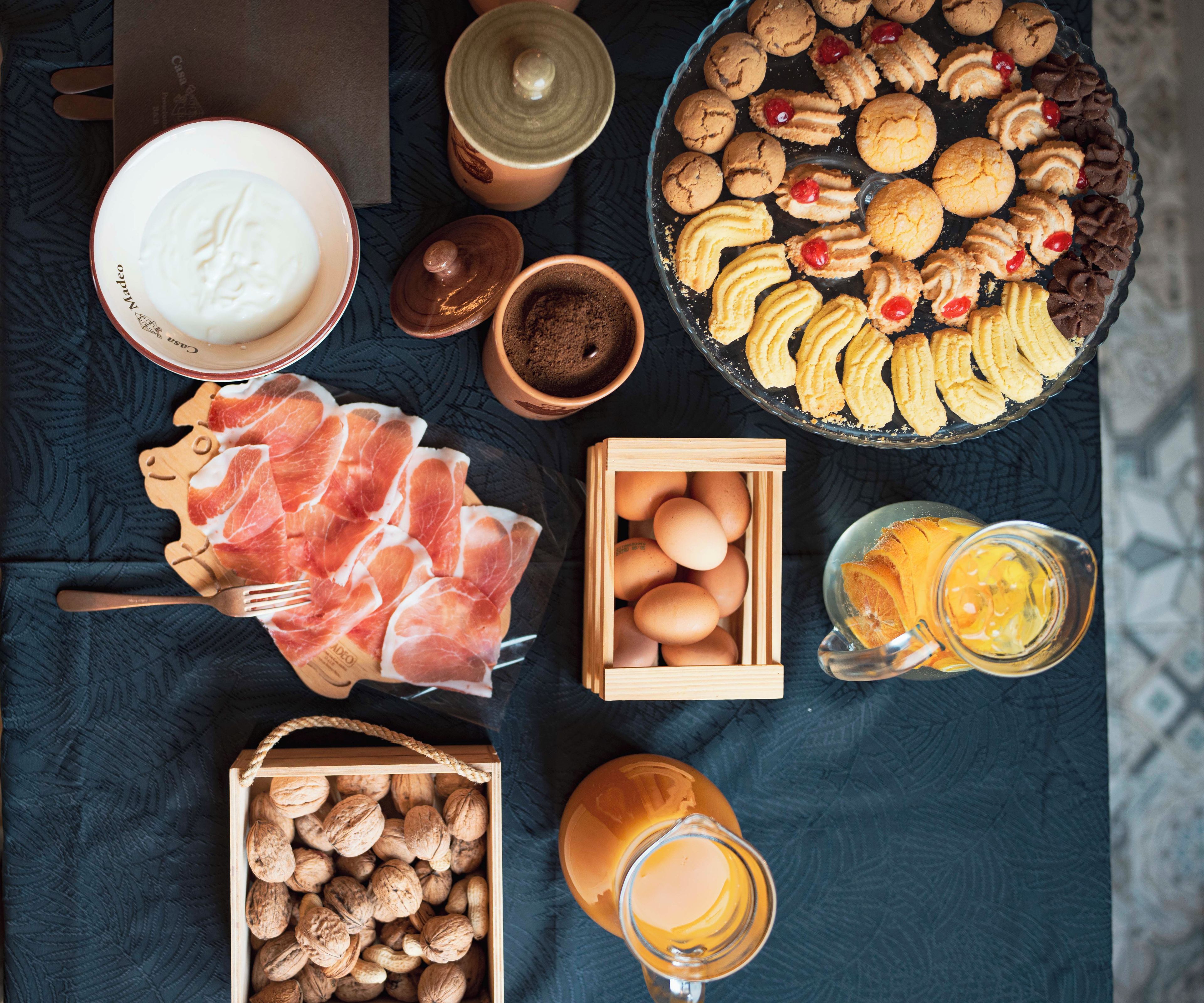 A variety of food items including cookies, eggs, and a glass of juice on a table.