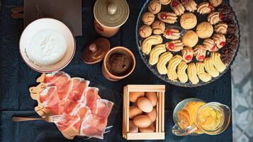 A variety of food items including cookies, eggs, and a glass of juice on a table.