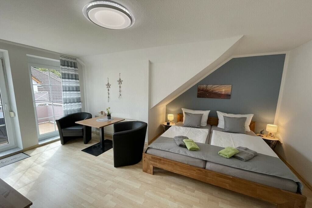 Un dormitorio moderno con cama estilo altillo, un escritorio pequeño y una silla.