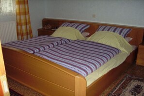 A single bed with a wooden frame and a patterned bedspread. - Holiday apartment with 1 bedroom (Steffeln)