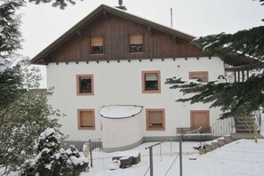 A two-story building with a white facade and brown roof. There are four windows on the second floor and two on the first. A staircase leads to the entrance. - Holiday apartment with 1 bedroom (Steffeln)
