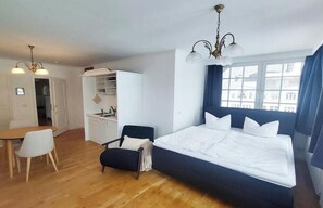 Ein Schlafzimmer mit Bett, Schreibtisch, Stuhl und Kleiderschrank.