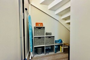 A storage area with wicker baskets and a blue chair.