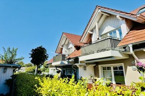 A residential building with a balcony, a window with a heart symbol, and a clear blue sky. - Holiday apartment with 2 bedrooms (Wustrow)