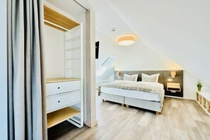Een slaapkamer met een bed, nachtkastjes, een kledingkast en een plafondlamp.