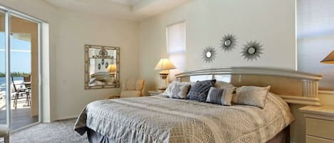 Een slaapkamer met een bed, een plafondventilator, een nachtkastje en een lamp.