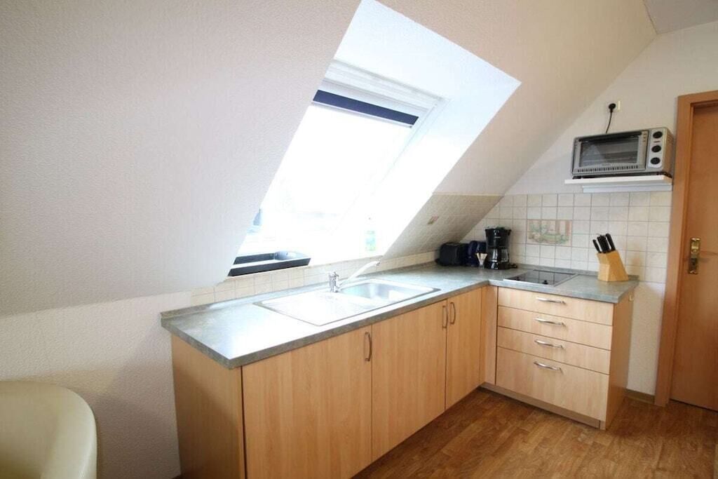 A kitchen with a skylight, a microwave, and a coffee maker.