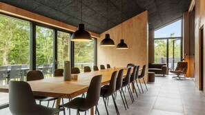 A modern conference room with a long wooden table, black chairs, and pendant lighting. - VillaVilla 994 - Øster Hurup, Østjylland (Hadsund)