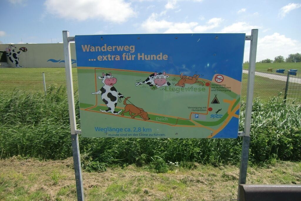 Ein Wegweiser für einen hundefreundlichen Wanderweg mit Karte und Entfernungsangaben.