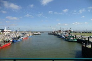 Un port de plaisance où sont amarrés de nombreux bateaux, un ciel dégagé et une étendue d’eau calme.