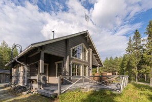 A cabin with a porch, a chimney, and a deck with outdoor furniture. - Ihtinginrinne | Peaceful 2BR Log Villa by the Lake (Ruka)