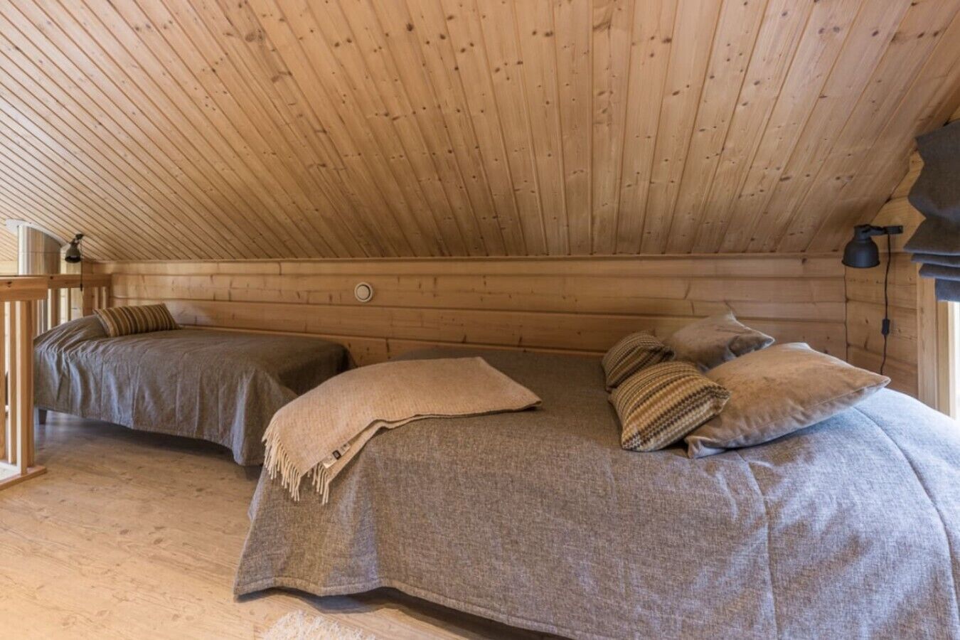 A cabin with two beds, wooden walls, and a simple, rustic design.