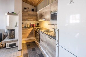 Eine moderne Küche mit Einbauofen, Spüle und Kühlschrank.