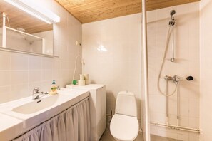 A bathroom with a shower, toilet, and sink. - Rukaköngäs D 17 | Comfy Apt with Fireplace & Sauna (Ruka)