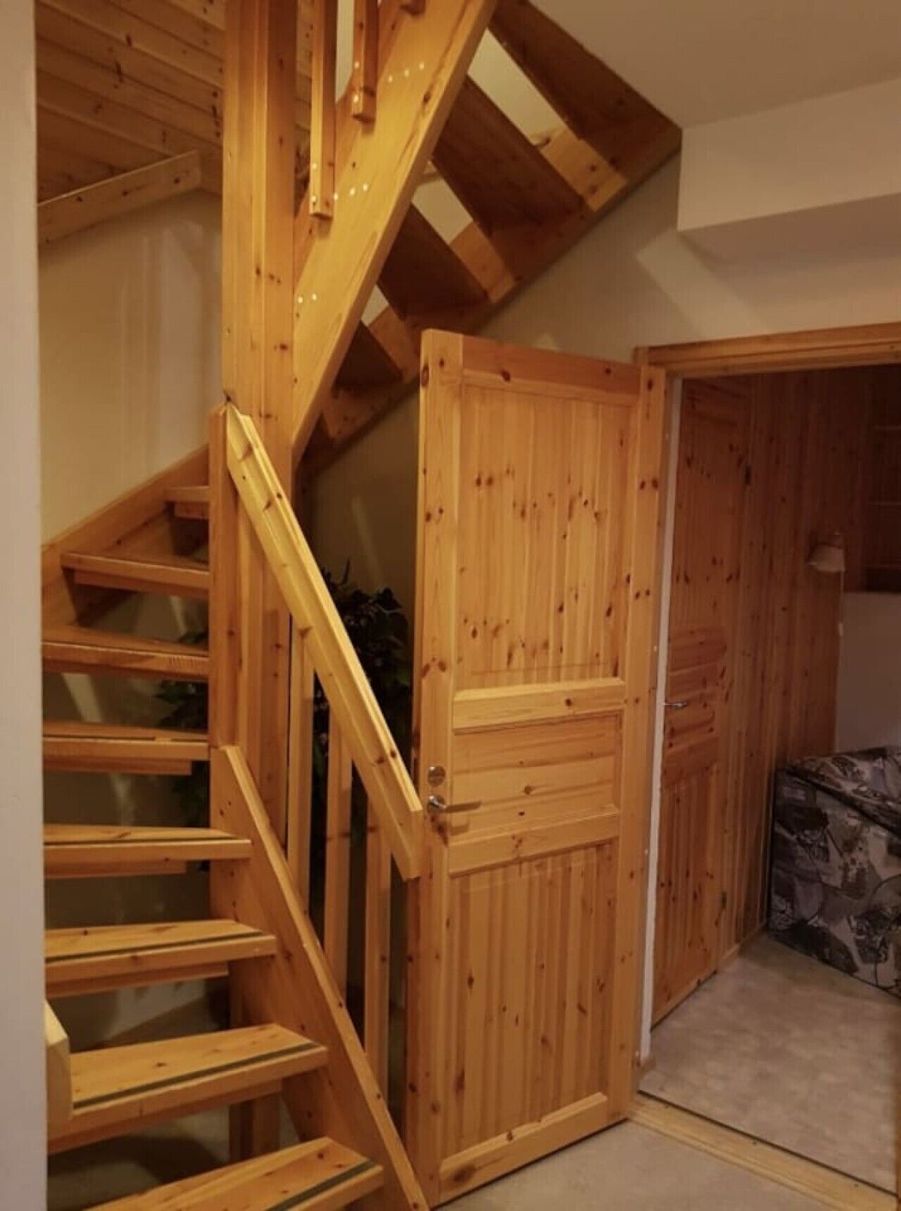 Una escalera de madera que lleva a una habitación con una puerta.
