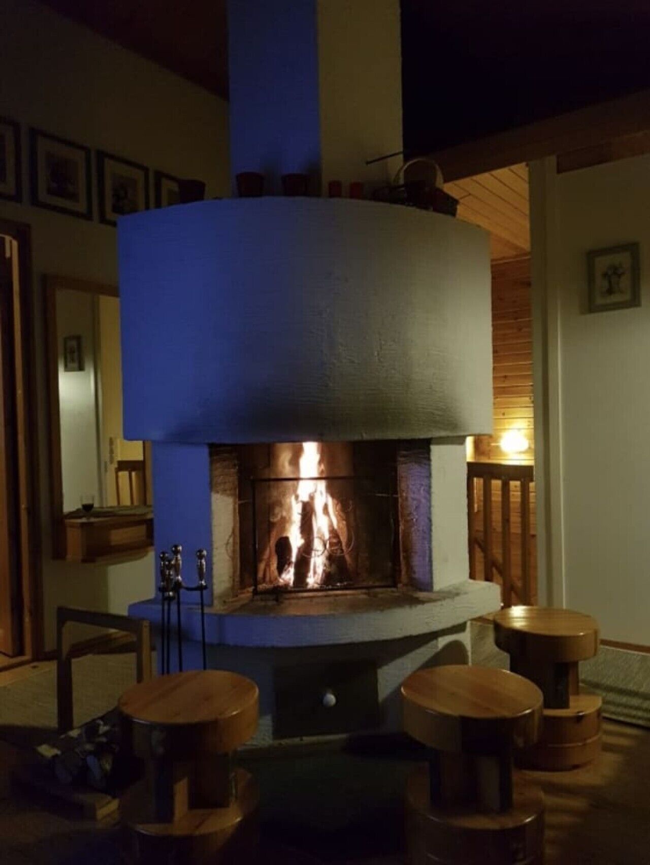 A room with a fireplace, wooden furniture, and framed pictures on the wall.