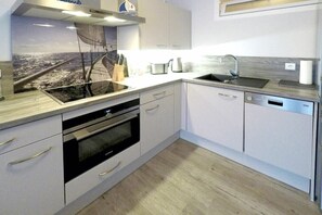 A modern kitchen with a built-in oven, a sink, and a dishwasher. - Holiday apartment with 1 bedroom (Dierhagen)