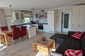 Eine moderne Wohnung mit Essbereich, Küche und Wohnzimmer.