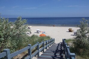 A beach with a wooden staircase leading down to the sand, a lifeguard chair, and beach umbrellas. - Holiday apartment with 2 bedrooms (Heringsdorf)